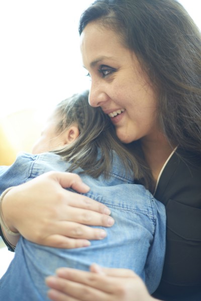 Hispanic mother hugging daughter