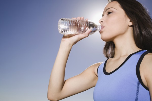 Thirsty Hispanic woman drinking water
