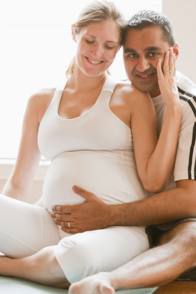 Man hugging pregnant woman's stomach