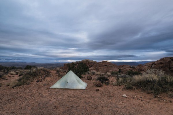Camping tent in landscape under clouds
