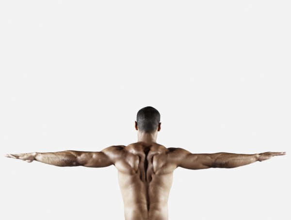 Bare chested mixed race man with arms outstretched