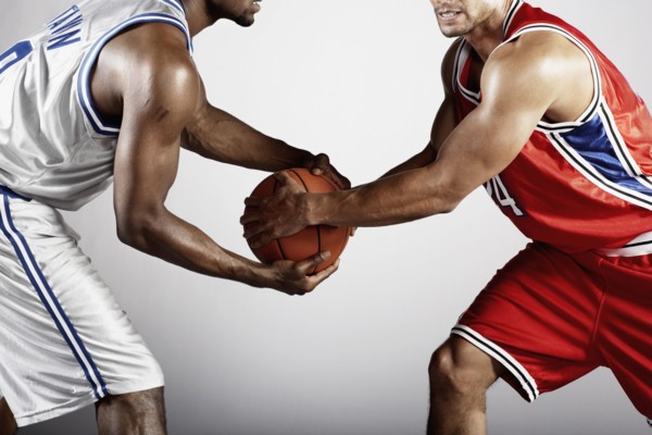 Basketball player trying to take basketball from opponent