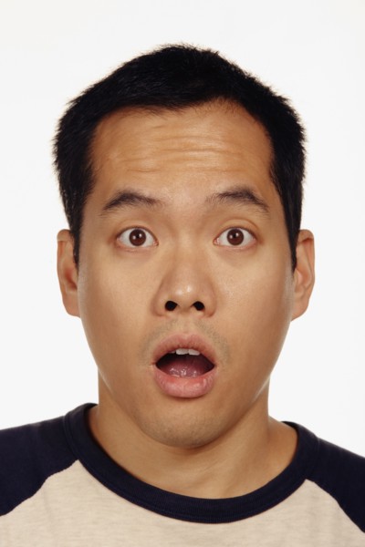 Close up studio shot of Asian man looking surprised