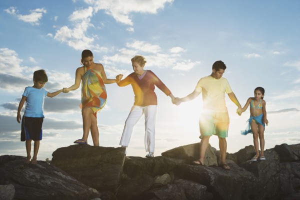 Low angle view of Hispanic family holding hands on rocks