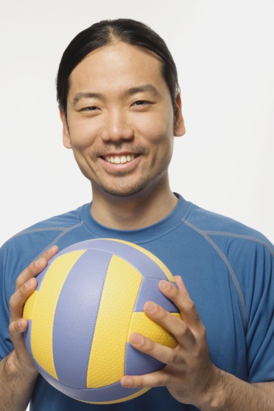 Asian man holding volleyball