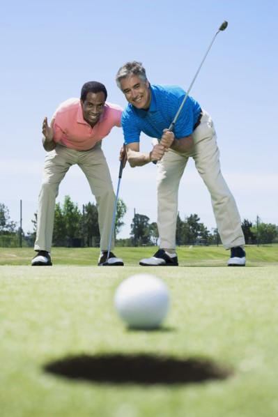 Multi-ethnic men looking at golf ball