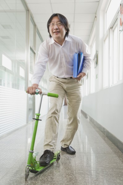 Chinese man riding scooter in corridor