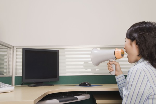Chinese businesswoman yelling at computer through megaphone