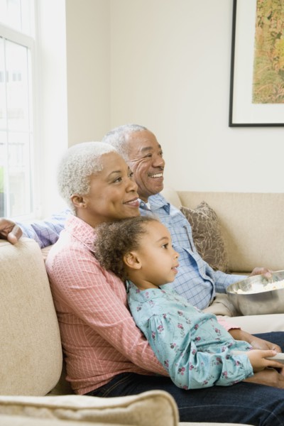 African grandparents with granddaughter in living room