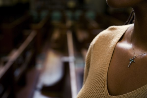 African woman wearing cross necklace in church