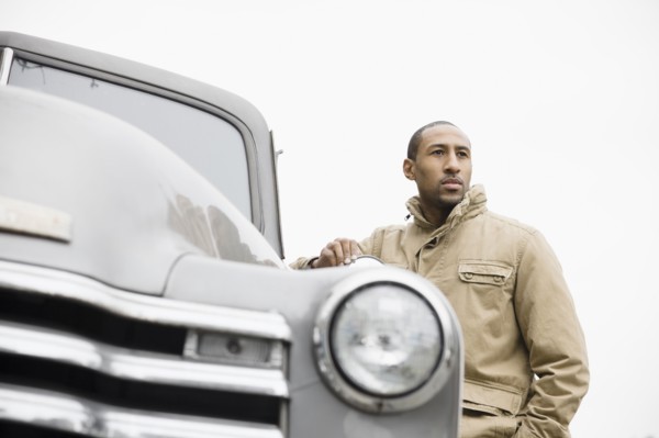 African American man standing next to old-fashioned truck