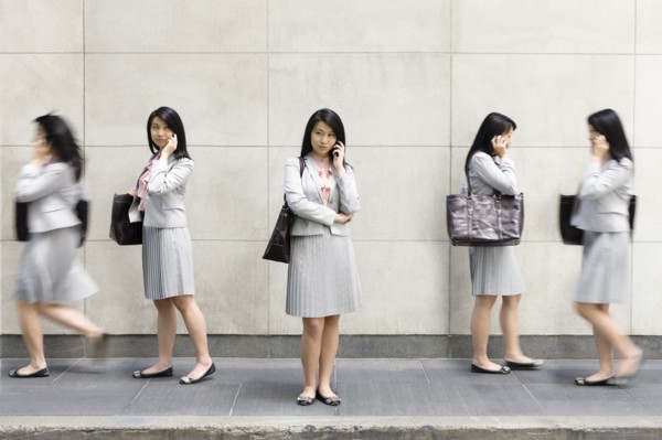 Multiple-exposure of Chinese businesswoman talking on cell phone