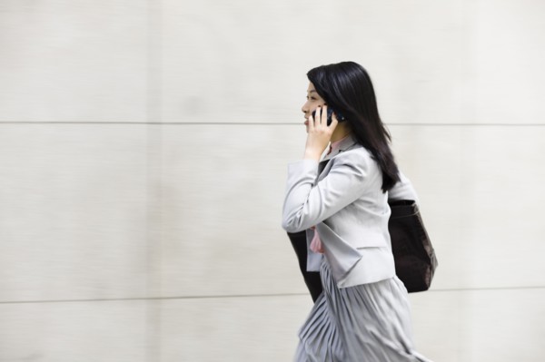 Chinese businesswoman walking and talking on cell phone