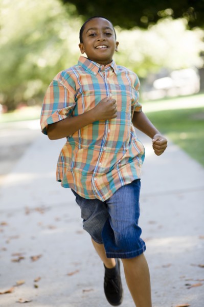 Mixed race boy running on sidewalk