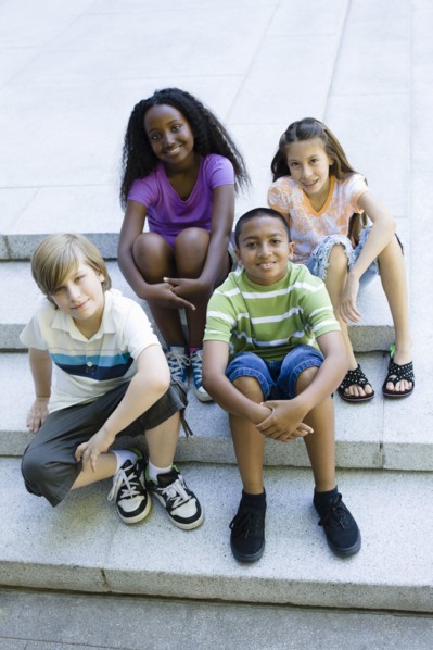 Smiling children sitting on steps together
