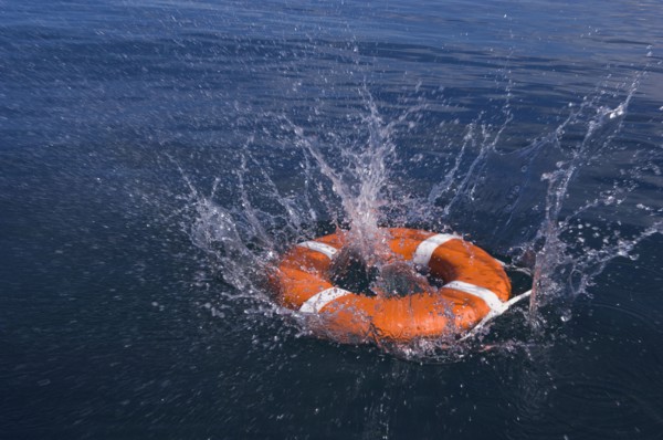 Round life preserver splashing into water