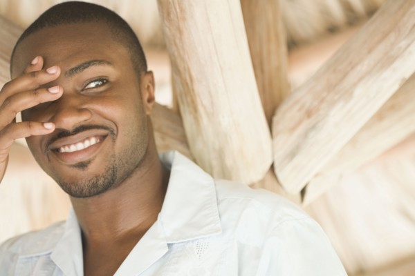 African American man with hand covering eye