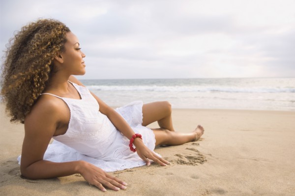 African woman laying on sand