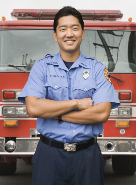 Asian firefighter next to fire truck