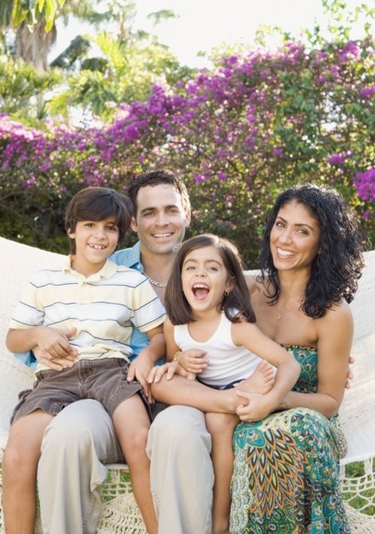 Smiling family sitting in garden
