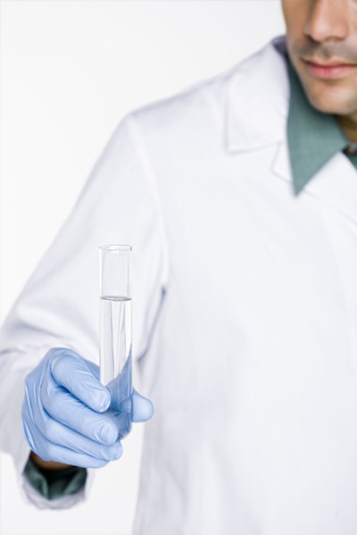 Hispanic scientist holding test tube full of water