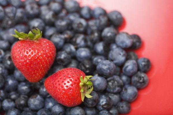 Strawberries on pile of blueberries