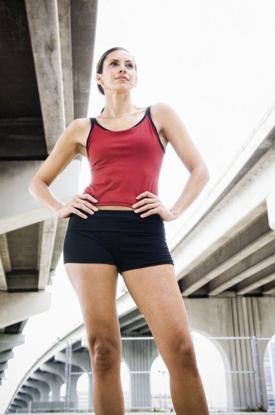 Hispanic woman in sportswear standing in urban area