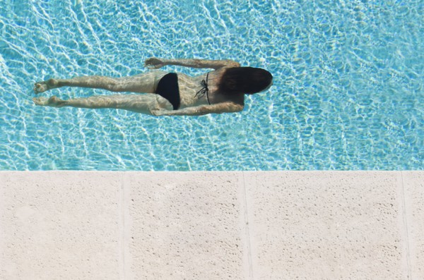 Mixed race woman swimming in pool