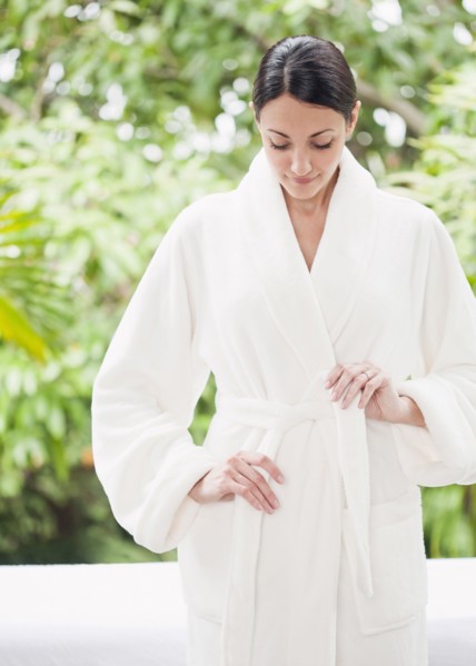 Caucasian woman tying bathrobe