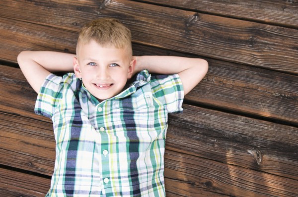 Caucasian boy laying on wooden deck