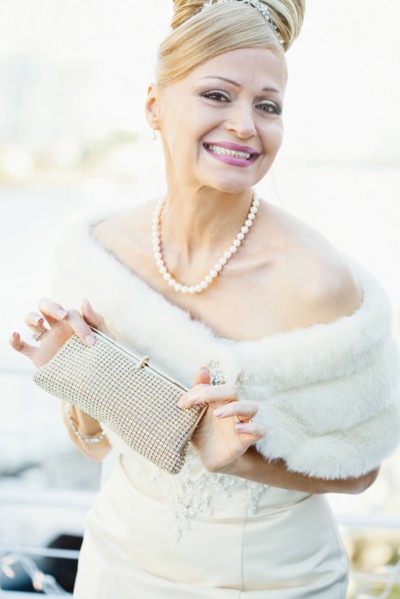 Smiling Hispanic bride holding purse