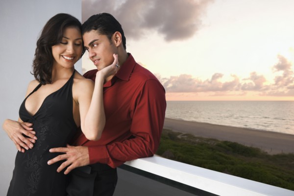 Hispanic couple hugging on balcony