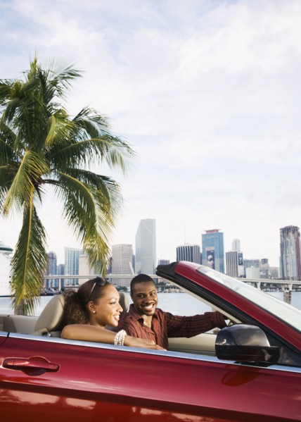 African American couple driving in convertible