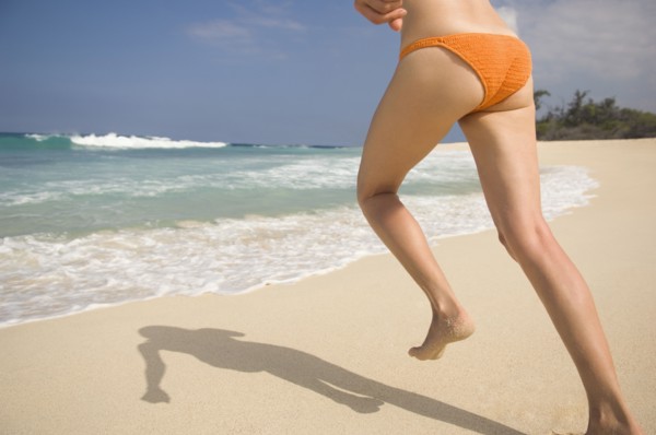 Caucasian woman running in bikini on beach