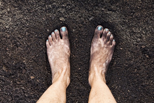 Mixed race woman barefoot in dirt