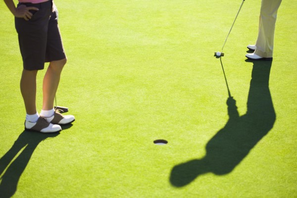 Women putting on green at golf course