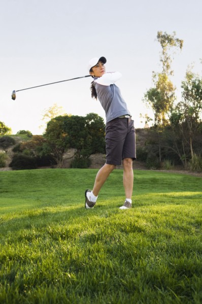 Mixed race woman playing golf on golf course