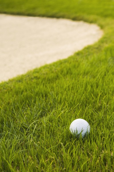 Close up of golf ball near sand trap on golf course