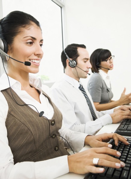 Customer service representatives wearing headsets using computers