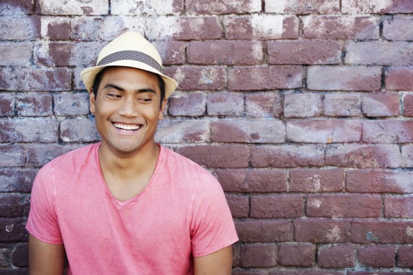 Smiling Asian man near brick wall