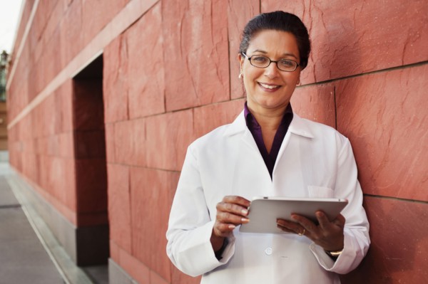 Doctor using digital tablet outdoors