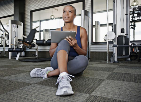 African American woman using digital tablet in health club