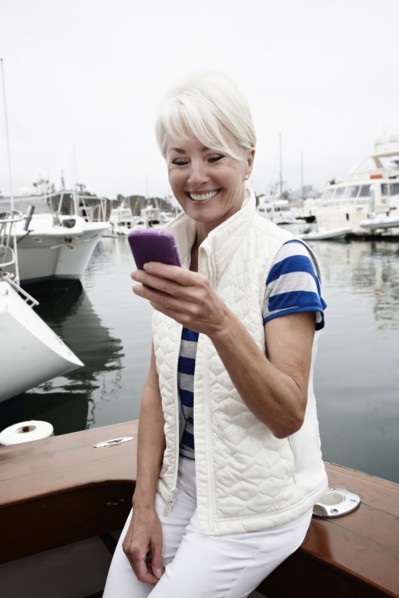Woman using cell phone in marina