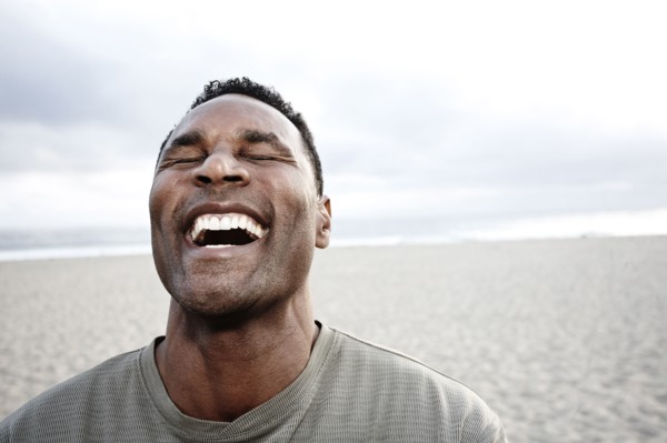 Black man laughing on beach