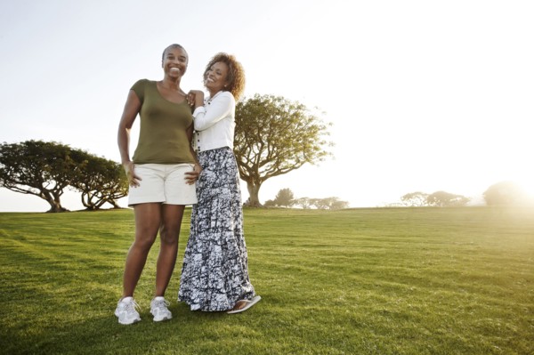 African American mother and daughter standing in park