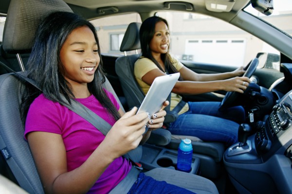 Girl using digital tablet in car