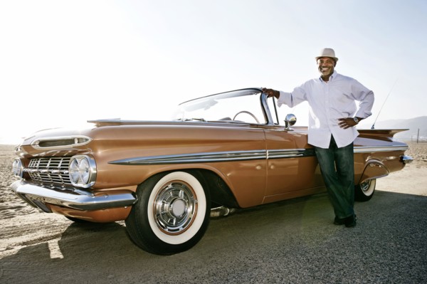 Black man leaning on convertible