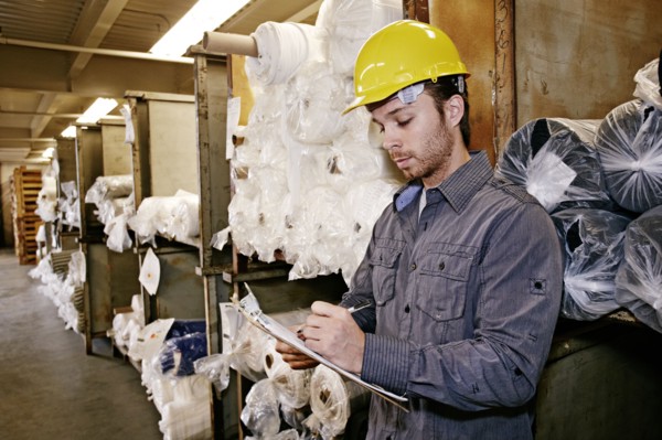 Caucasian worker checking product in warehouse