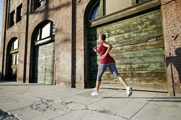 Black woman running on city street