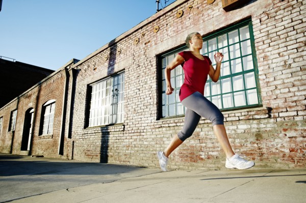 Black woman running on city street